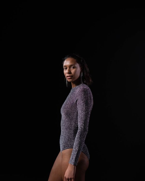 Athlete in a powerful yoga warrior pose against a dark background.